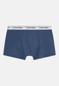 Tamnoplave bokserice od mekog materijala s bijelim elastičnim pojasom na kojem se nalazi logo "Calvin Klein". Srednji struk, bez uzoraka.