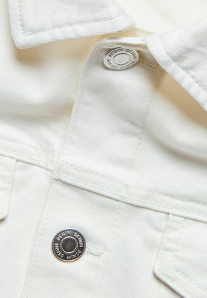 Valkoinen denimi kangas, jossa on kauluspaita-malli, metallinen nappi, näkyvät tikkausominaisuudet ja taskudetail. Pintakuosi on yleisesti sileä.