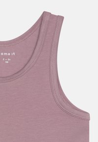 Lilac tank top with a round neckline, thin shoulder straps, and visible smooth fabric texture. Reinforced stitching accents the edges.