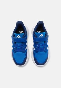 Niebieskie buty sportowe z siateczkową cholewką, białym wzorem w trzy paski i zapięciem na rzep. Oferują wyściełany język i teksturowaną podeszwę.