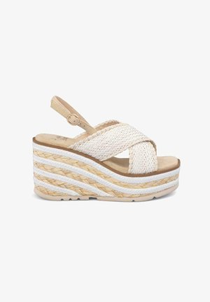 Sandalia cuña con parte superior de textil tejido color crema, tiras cruzadas y una plataforma tipo corcho con detalles trenzados en blanco y marrón alternados.