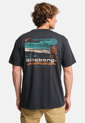 Maglietta nera in cotone con una stampa grafica colorata sulla parte posteriore, con la scritta "Billabong Adventure Division" e design astratti.