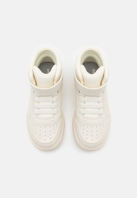 Zapatillas altas de cuero color blanco roto con diseño de cordones, cuello acolchado en el tobillo y caja de puntera perforada. Suela de goma para mayor tracción.