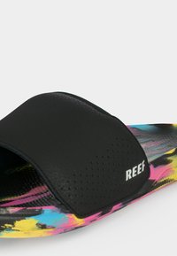 Sandale noire à enfiler avec une bride perforée et le logo « REEF », dotée d’une semelle intérieure et d’une semelle extérieure à motif tie-dye multicolore.