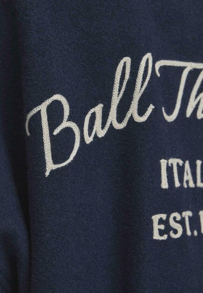 Pulover din lână bleumarin cu text brodat în crem „Ball This” și „ITALY EST.” Textură moale, croială casual și fără închideri vizibile.