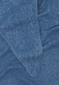 Blauwe textuurstof met een zachte, pluizige oppervlakte en een lichte glans. De randen zijn afgewerkt met een gladde naad.