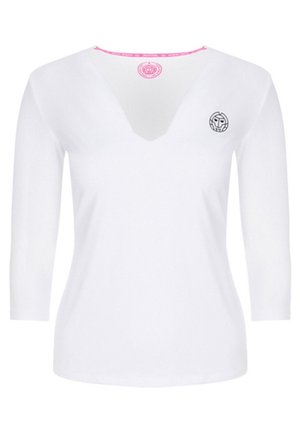 Haut blanc à manches longues pour femmes avec col en V, petit logo circulaire noir sur le côté gauche de la poitrine, et étiquette ronde rose à l'intérieur du col.