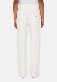 Pantalones de algodón blancos con una cintura alta y dos bolsillos traseros. Presentan un parche con el logo en el bolsillo derecho y un diseño de pierna recta.