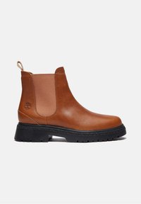 Bottine Chelsea en cuir marron avec semelle noire épaisse, panneaux latéraux élastiques, languette à talon et logo de marque embossé sur le côté.