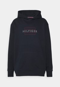 Sudadera azul marino hecha de un tejido suave con un bolsillo frontal, que presenta un logo rectangular de "HILFIGER" en bordado rojo y blanco en el pecho.