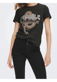 Camiseta de algodón gris oscuro con un diseño gráfico que presenta una serpiente y la palabra "TROUBLE" en letras grandes. Mangas cortas y corte relajado.
