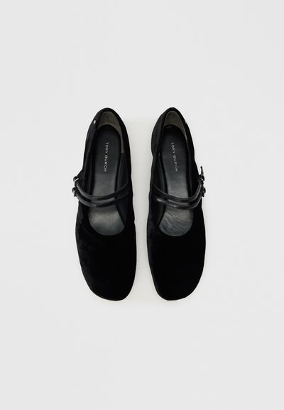 Ballerines en suède noir avec un bout arrondi, dotées d'une fine sangle noire sur le cou-de-pied et d'une doublure intérieure douce et lisse.