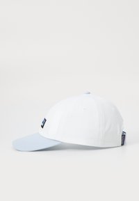 Fehér baseball sapka világos kék peremmel, fekete logóval elöl, és több fehér szellőzőlyukkal a tetején.