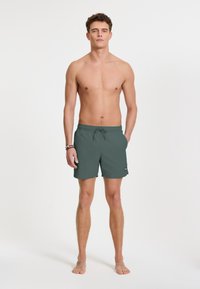 Sötétzöld férfi usz shorts, rugalmas derékkal és zsinórral. Könnyű anyag, sima tapintással.