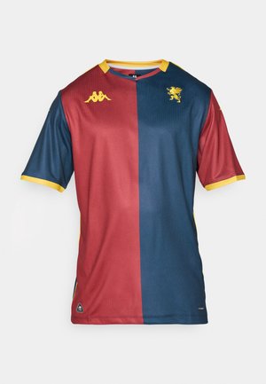 Red and blue sport jersey with short sleeves, featuring yellow accents and a lion emblem. Made from breathable, textured fabric.
