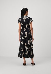 Melna ziedu kleita ar īs�ām piedurknēm, izsistām vidukļa daļām un plūstošu midi garumu. Ar krēmkrāsas ziedu rakstiem un smalku spīdumu.