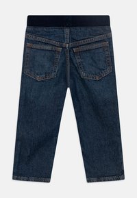 Jean en denim bleu foncé avec une taille côtelée, doté de deux poches arrière et d'une coupe droite. Tissu texturé avec des coutures contrastées.