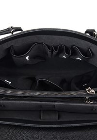 Sort læderhåndtaske interiør med flere rum og lynlåsfelt, med glat tekstur og stofforing.