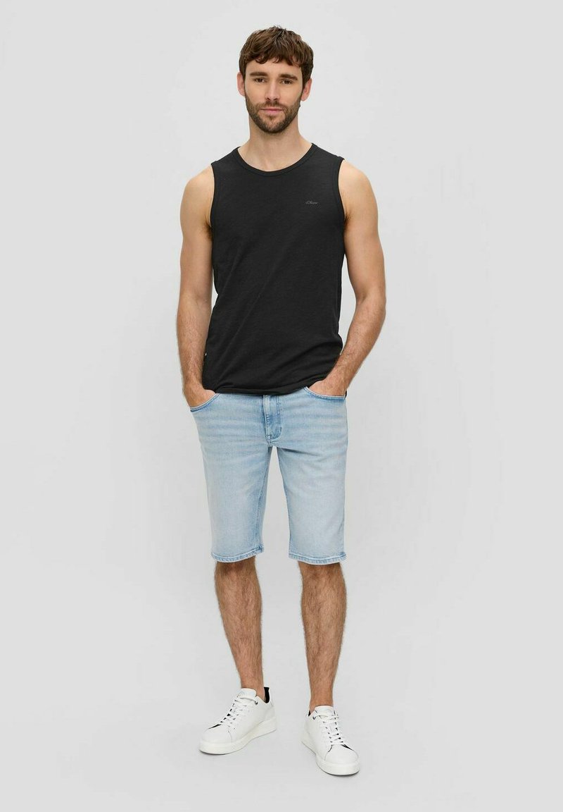Schwarzes Baumwoll-Ärmellos-Shirt, hellblaue Denim-Shorts und weiße Sneaker. Einfaches Design mit lässigem Schnitt und ohne sichtbare Muster oder Logos.