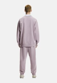 Hellvioletter Pullover und passende Jogginghosen aus weichem Stoff, mit lockerem Schnitt, elastischen Bündchen und dezenten Logodetails.