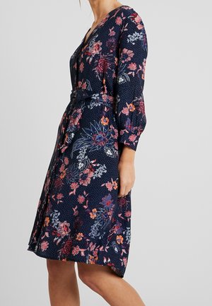 Vestido envolvente floral en azul marino con patrones en rojo, rosa y azul. Cuenta con mangas largas, un cinturón y una textura de tela suave.