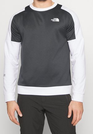 Grå og hvid langærmet skjorte med tekstureret grå krop, glatte hvide ærmer, ribbet krave og manchetter samt et lille logo på brystet.