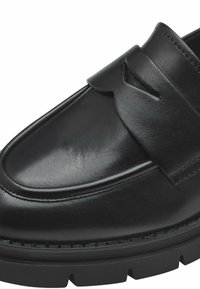 Mocassin en cuir noir avec une finition brillante, mettant en avant un détail de lanière proéminent et une semelle noire épaisse et texturée. Design simple et épuré.