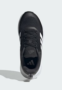 Chaussure de sport noire avec tige en maille, design à trois rayures blanches, accents texturés et semelle légère. Les lacets sont noirs avec œillets renforcés.