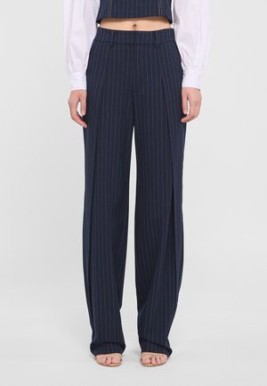 Pantalons à rayures navy avec une coupe large. Fabriqués en tissu doux, dotés de plis avant et d'une taille cintrée.