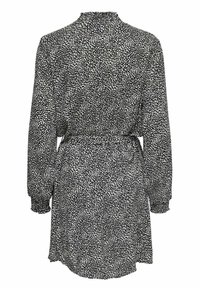 Vestido de patrón en blanco y negro con mangas largas, cuello alto, cinturilla elástica y un ajuste holgado. Presenta un dobladillo de longitud media.