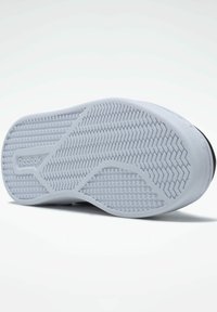 Semelle de sneaker en caoutchouc blanc avec un motif herringbone texturé. Présente un bord lisse et le logo Reebok près du talon.