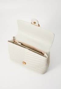 Balta ādas rokassomiņa ar kvadrātveida červona rakstu, zelta krāsas detaļām, magnētiskā aizdare un viena iekšējā rāvējslēdzēja kabata.