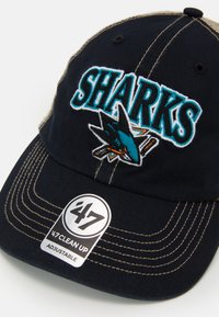 Mornarsko plava baseball kapa s izvezenim logotipom "SHARKS" u tirkiznoj i narančastoj boji, s unaprijed zakrivljenim vizirom i podesivim remenom.