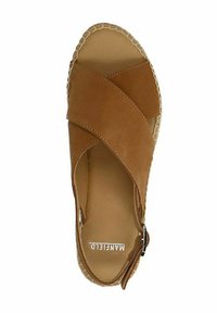 Espadrille en daim marron avec des sangles croisées, talon fermé et semelle en jute tressé. L'intérieur présente une doublure beige lisse avec le logo.