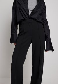 MIT WEITEN BEINEN - Trousers - black