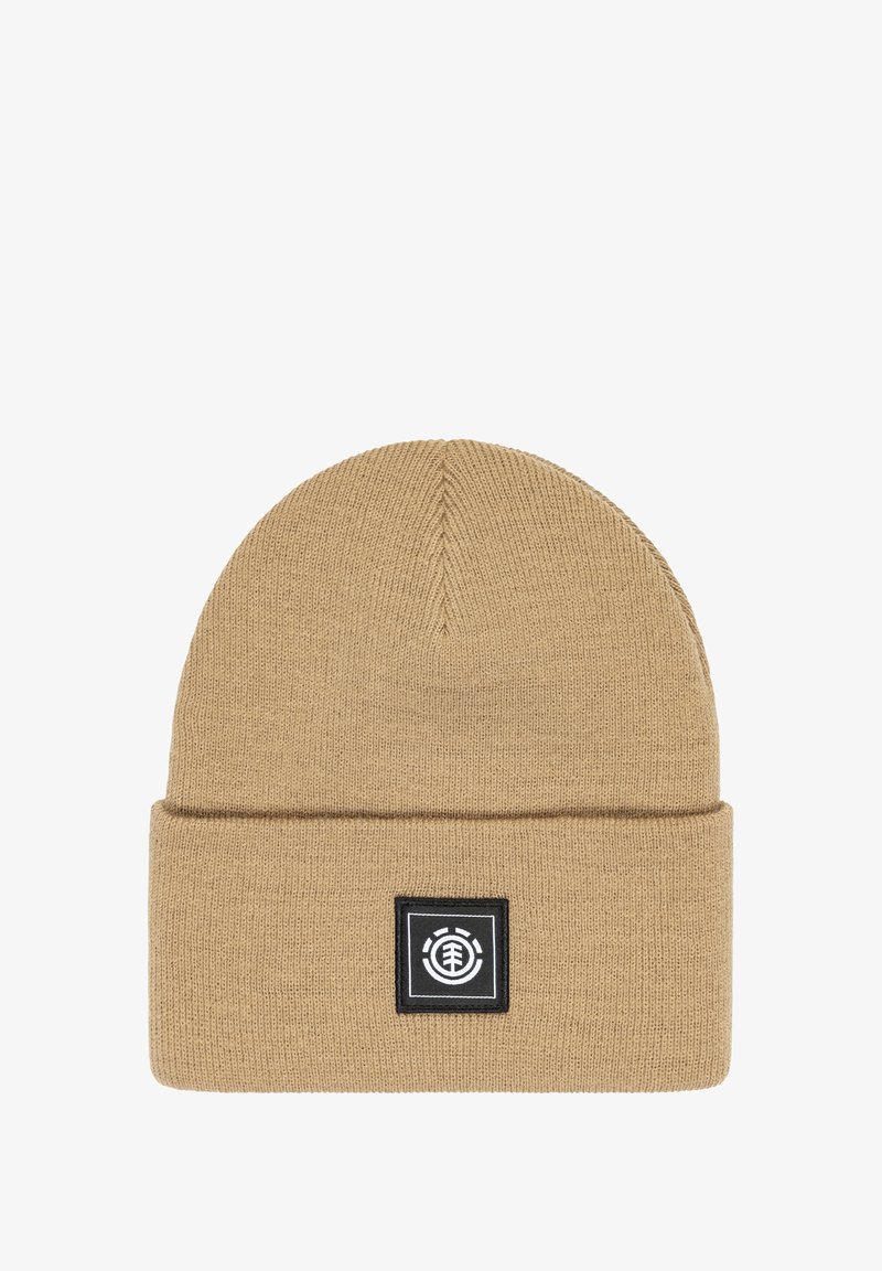 Gorro de punto beige con vuelta, que presenta un parche de logo cuadrado negro. El material parece suave y texturizado, con un diseño de corona sin costuras.