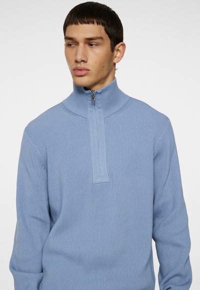 Himmelblaues Half-Zip-Pullover mit geripptem Textur, hohem Kragen und silbernem Reißverschluss. Verfügt über lange Ärmel und eine figurbetonte Silhouette.