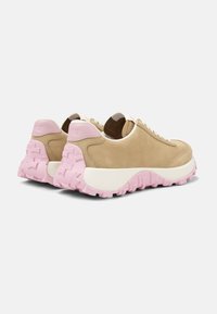 Beige suede sneakers with a pink rubber outsole, cream midsole, and lace-up design. Features a padded collar and textured accents on the heel.