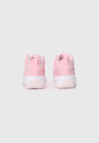 Zapatillas deportivas de color rosa claro con un material texturizado, que presentan una suela blanca y detalles en blanco, tirador en el talón, y un logo bordado.