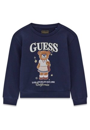 Sweat-shirt bleu marine avec un ours en peluche portant une jupe et un pull, avec le texte "GUESS" et "Los Angeles Est. 1981 California."