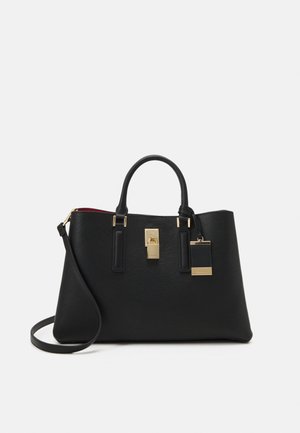 Sac à main synthétique noir avec une finition texturée, quincaillerie dorée, un détail de cadenas et une bandoulière détachable. Doublure intérieure rouge.