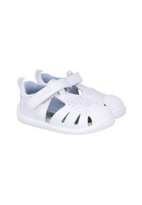 Sandalias blancas para niños con un diseño transpirable, que cuentan con cortes, una cinta de velcro y tapas de protección para los dedos. Material suave y suela flexible.