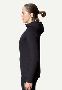 Schwarze, strukturierte Zip-Hoodie mit einer taillierten Passform und hohem Kragen. Verfügt über lange Ärmel und eine Kapuze. Die Seitenansicht zeigt eine schlanke Silhouette.