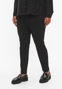 Svarta byxor med ett texturerat blommönster, rak passform och en slät yta. Matchas med svarta loafers med en tjock sula.