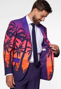 Chaqueta de traje con un vibrante diseño de atardecer con palmeras. Los colores incluyen púrpura, naranja y rosa. Forrada con una tela interior a juego.