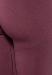 Marron Stretch-Leggings verfügen über eine glatte, matte Textur mit flachen Nähten. Die enge Passform schmiegt sich an die Körperform an und verbessert den Komfort sowie die Beweglichkeit.