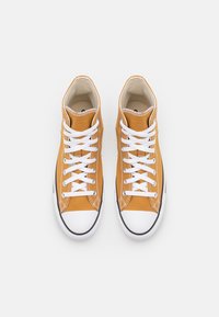 Pair of orange high-top canvas sneakers with white rubber toes and white laces on a plain white background.