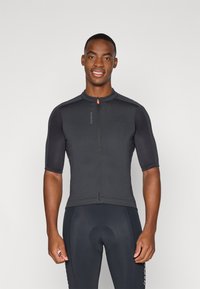Maglia da ciclismo a maniche corte di colore nero solido, con zip frontale, colletto rotondo e tessuto texturizzato. Design aderente con branding minimo.
