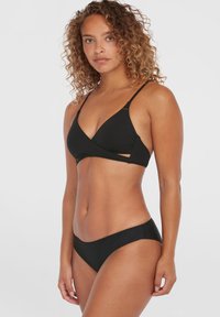 Svart bikinitsett med en trekantet bralette med innpakket design og tynne stropper, kombinert med mid-rise, sømløse bikiniunderskjørt.