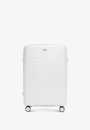 Maleta dura blanca con diseño de rayas horizontales, textura suave, asa superior y cuatro ruedas para facilitar la maniobrabilidad.